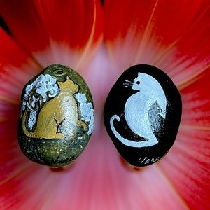 Hand crafted painted black white cat rock Brown angel cat natural background